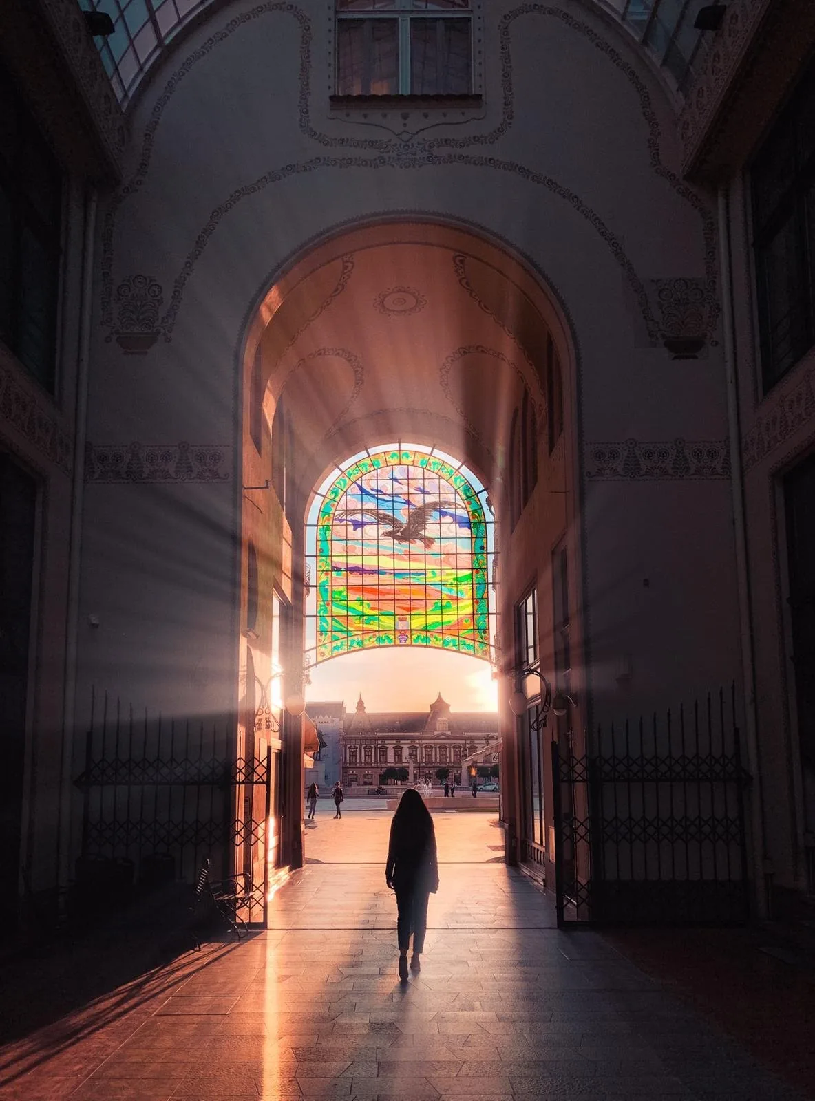 Sunlight streaming through the stained-glass passage of the Black Eagle Palace